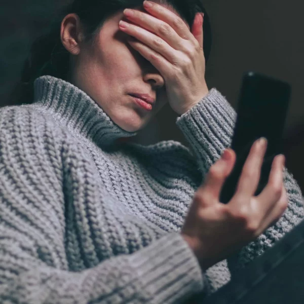 Person reading a message on their phone, trying not to respond emotionally