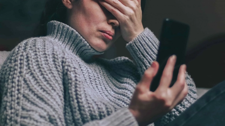 Person reading a message on their phone, trying not to respond emotionally
